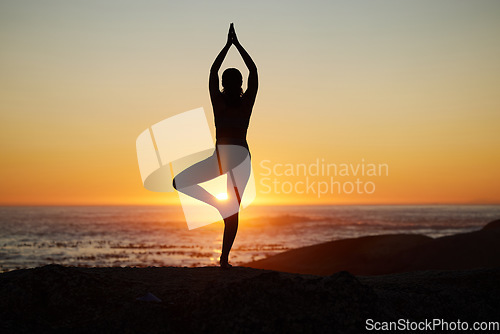 Image of Woman, silhouette or sunset yoga on beach by ocean, sea or water horizon for mental health, relax exercise or sun salutation. Calm, zen or peace yogi in tree pose at Bali nature for sunrise pilates