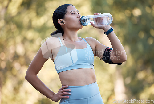 Image of Woman, fitness and drinking water for wellness, health and hydration outdoor in park with bottle. Runner, rest and water in nature for exercise, running or workout in summer sunshine in Los Angeles