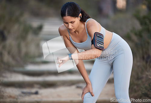 Image of Fitness, runner and woman running with smartwatch, check time and health monitor, heart rate and cardio during workout outdoor. Exercise, break and training for marathon or wellness with sport tech.