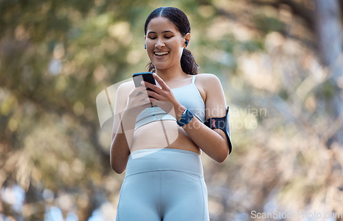 Image of Phone, earphones and woman in nature for fitness, running music or radio, podcast or audio outdoors. Wellness, health or female athlete on 5g mobile smartphone browsing social media on training break