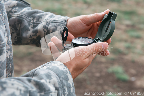 Image of Man with compass in hand outdoor