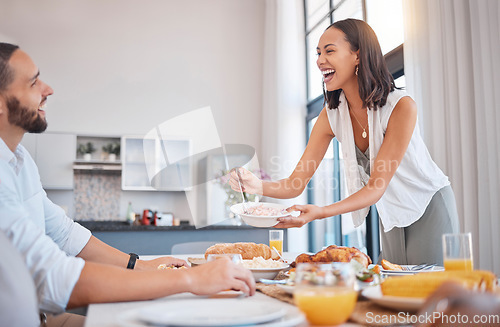 Image of Happy, smile and couple eating dinner together at the dining room table in their modern house. Happiness, love and woman dishing food for her husband while enjoying a meal on a date at their home.