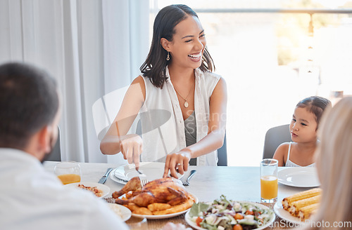 Image of Chicken, happy and family lunch with woman cutting with knife, meal and food in dining room or celebration event. Love, happiness and group of people eating or laugh at brunch in family home together