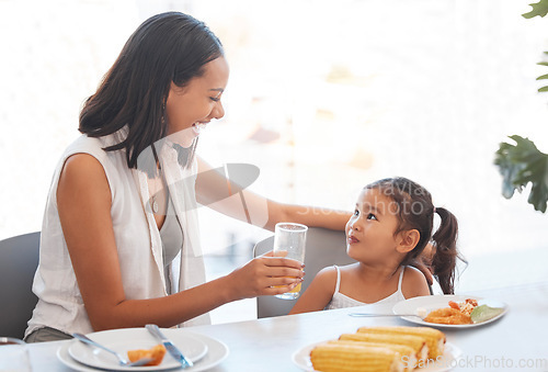 Image of Woman, food and eating at home for health, wellness and diet nutrition at the dining table. Meal, lunch and mother and daughter eat and drink juice together for hungry child in the family home