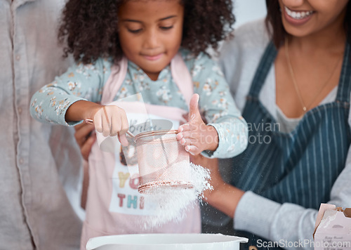 Image of Hands, children and baking with a girl learning how to bake in the kitchen of her home with mother. Flour, kids and cooking with a female child and parent teaching about ingredients for a recipe