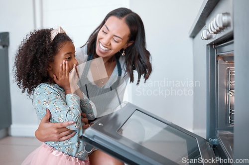 Image of Woman, child and baking at the oven while waiting with surprise for food or baked food. Mother, daughter and kid using a convection stove or oven for cooking or bake meal in the family home to bond