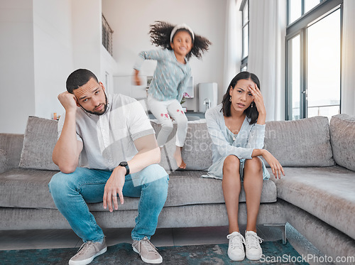 Image of Tired, couple and family with adhd girl jump fast on sofa in house living room or home. Man, woman and parents with burnout, depression or anxiety from autism, energy and mental health kid and stress