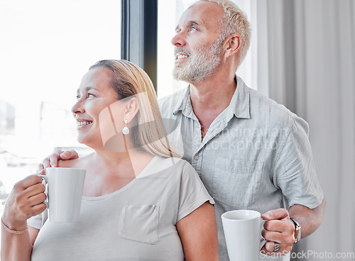 Image of Elderly couple, hug and coffee by window with smile in contemplation, vision or morning routine at home. Happy senior man and woman smiling looking out glass while enjoying a warm drink together