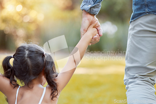 Image of Holding hands, care and girl with father in a park with safety, support and security. Walk, trust and back of a child with dad in a backyard, field or nature in countryside for outdoor quality time