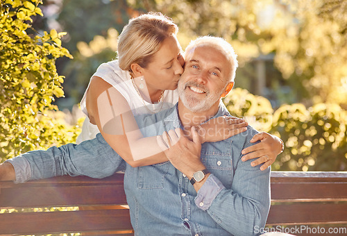 Image of Love, relax and happy with old couple in park bench for retirement, support and affectionate. Bonding, kiss and hug with portrait of man and woman in countryside for smile, nature and marriage