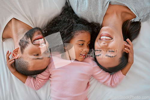 Image of Top view, love and parents with child in bed bonding, smiling and enjoy morning together. Family, happiness and aerial of young girl in bedroom for quality time, affection and relax with mom and dad