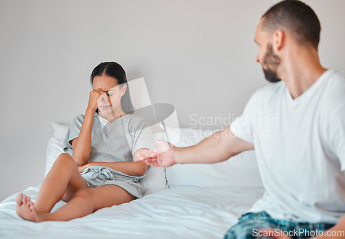 Image of Comfort, crying and sad couple in bed after fight, argument and disagreement at home. Love, marriage and young man reaching to console upset and depressed woman sitting in bedroom to fix relationship