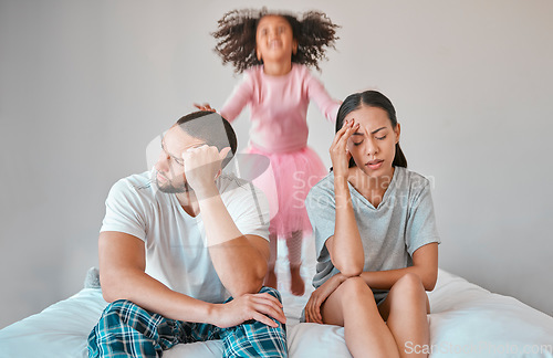 Image of Stress, divorce and couple with a child on the bed with her parents in an argument or disagreement. Tired, break up and young angry mother and father with a adhd girl jumping in bedroom at their home