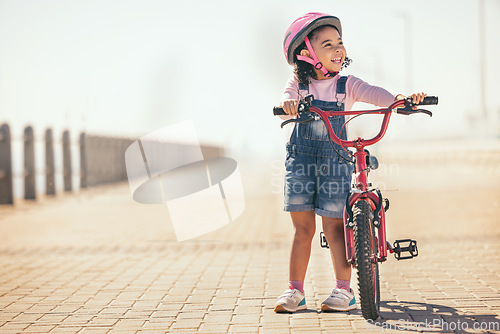 Image of Fun, thinking and girl cycling with a bike in the city for sustainability, carbon footprint and eco friendly transport. Happy, smile and child with an idea and a bicycle in the street for happiness