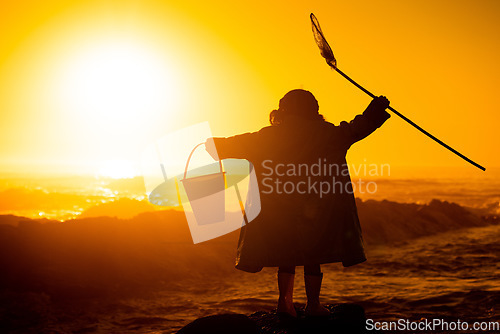 Image of Silhouette, sunset and child at beach with toys for travel, holiday and playing by water in Australia. Earth day, ocean and back of girl kid in the dark during sunrise to play and relax on vacation