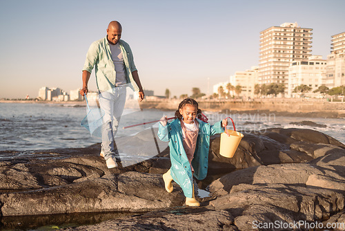 Image of Father, girl and fishing at beach, learning and happy together outdoor in summer, bonding or fun on rocks. Black man teaching kid to catch fish, rod and bucket with family at a ocean, sea and nature