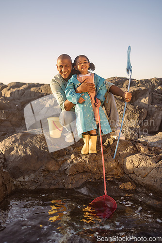 Image of Father, girl or bonding and fishing by beach, ocean or sea rock pools with plastic bucket and nets on summer holiday. Portrait, smile or happy child or kid with man catching fish, shrimp or muscles
