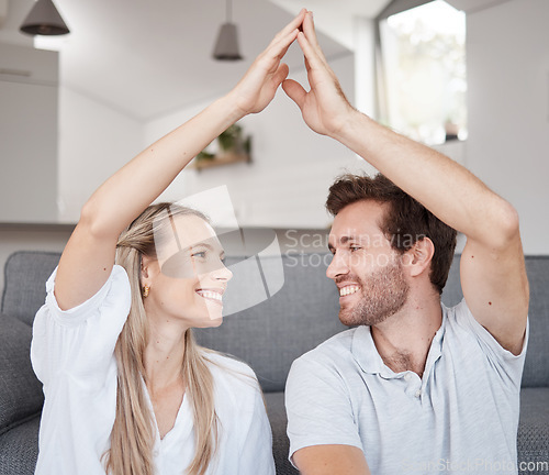 Image of Couple, roof hands and happy together on floor in bedroom of new home, safety insurance and happiness in family home. Marriage, security and protection support for love, care and house mortgage