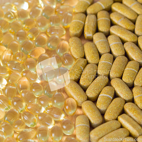 Image of Fish oil capsules and multivitamin tablets on a table