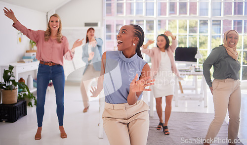 Image of Business, women and group dance for fun celebration in a creative office for campaign success with diverse staff. Joy, excitement and dancing with a multicultural team of ladies celebrating