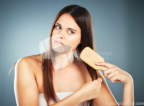 Image of Beauty, hair and wellness model with brush thinking of self care, frizz and grooming straight hair. Shine, health and hair care woman in gray gradient studio mockup for cosmetic advertising.