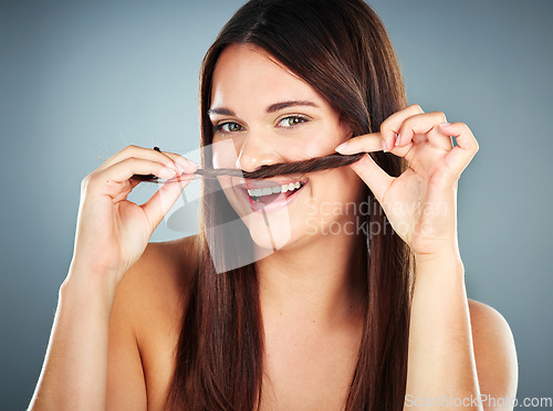 Image of Hair care, shine and portrait of a salon woman with comic self care against a blue studio background. Beauty, smile and funny hair model with cosmetics from luxury hair salon keratin treatment