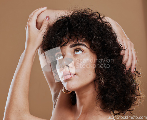 Image of Curly hair, woman and freckles, beauty and makeup for glow, shine and hair care on studio background. Young girl model, melasma face and natural cosmetics, clean skincare and dermatology aesthetics