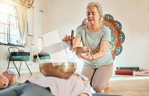 Image of Meditation, tibetan bowl and zen senior women doing a sound healing or therapy practice in a studio. Peace, calm and elderly friends with a singing bowl for body and mind wellness, health and balance