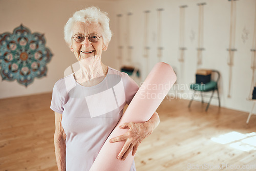 Image of Yoga, mat and portrait of a senior woman in a wellness studio for an exercise or meditation class. Happy, smile and elderly female in retirement at mind and body pilates workout for peace and balance