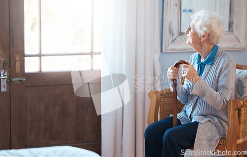 Image of Thinking, sad and senior woman thinking of life with a walking stick by the window in the room in a retirement house. Elderly female with depression, disability and retirement idea in a nursing home