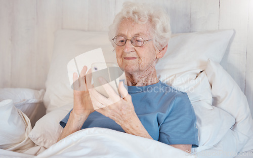 Image of Phone, bed and senior woman in nursing home surfing internet, social media or nostalgic photographs with happy memories. Communication, technology and grandma in bedroom of retirement home with smile