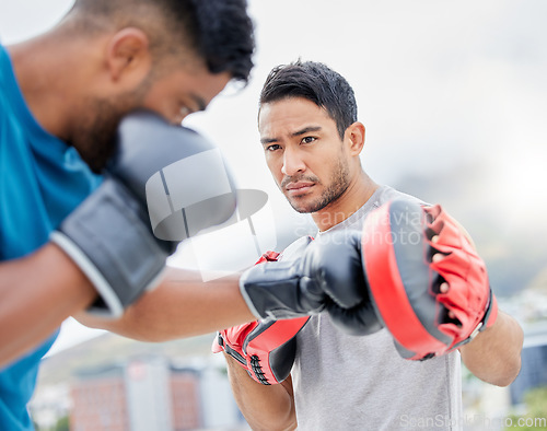 Image of Fitness, personal trainer and boxing exercise for sports competition, training or self defense practice in the city. Boxer doing intense power workout with coach in preparation for competitive fight