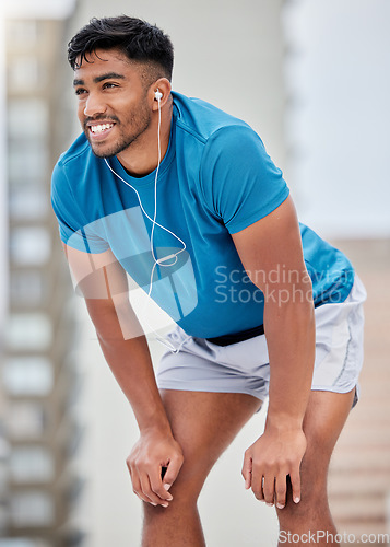 Image of Fitness, rest and runner stop to relax or breathe on outdoor run or workout with headphones. Health, training and wellness, a tired sports man on break from running exercise while streaming music app