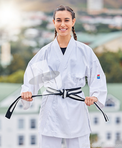Image of Karate, ready and portrait of a woman training on a rooftop for professional event, competition and fight. Black belt, fitness and taekwondo girl with a smile for sports, body power and martial arts