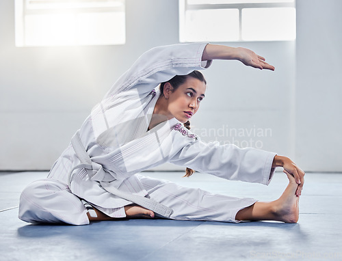 Image of Martial arts, karate or woman stretching before training practice, fitness workout or challenge competition. Girl, warrior or taekwondo fighter warm up for dojo self defense or safety security lesson