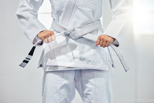 Image of karate belt, martial arts and woman ready for fight battle, white dojo training or fitness challenge workout. Warrior motivation, taekwondo and hands of girl learning self defense for safety security