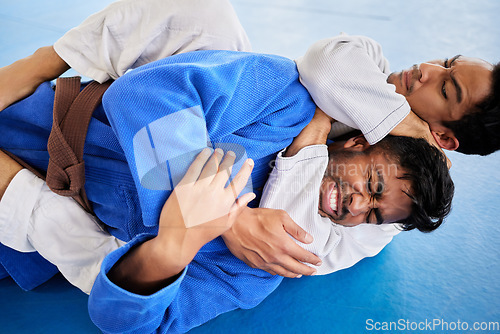 Image of Men, martial arts and karate choke hold in dojo to practice fighting skill. Training, taekwondo and fitness class for self defense, workout or exercise challenge with people in match or competition.