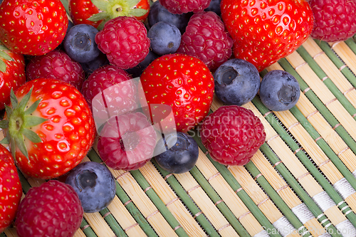 Image of Variety of berries - trawberries, blueberries, raspberries scattered