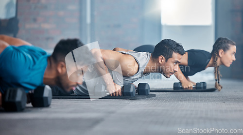 Image of Fitness, exercise and gym with a personal trainer teaching or training a class workout in a health club. Motivation, coach and dumbbells with a man athlete and student group in a session for strength