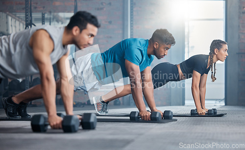 Image of Group, workout and dumbbell push up at gym for muscle, power or strength. Teamwork, sports or energy of people, athletes or bodybuilder friends exercise or training at fitness center for healthcare.