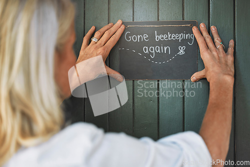 Image of Small business, door sign and beekeeping with a woman outdoor for agriculture, bee farming and manufacturing of honey for shop. Female closing starup store for apiarist, beeswax and honeycomb work