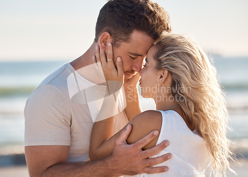 Image of Love, kiss and beach with a young couple sharing an intimate moment on the coast by the sea or ocean. Nature, romance and travel with a man and woman bonding together on an outdoor date in summer