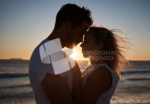 Image of Sunset, silhouette and couple with love at the beach, affection and quality time on a holiday in Bali. Dark, sunrise and man and woman with care, hug and peace by the tropical water on vacation