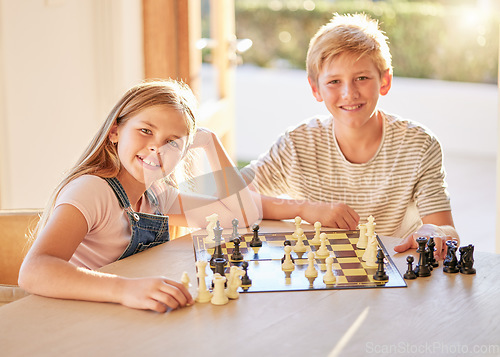 Image of Portrait, chess and children relax at a table with board game, bond and learning in a living room in their home. Kids, chessboard and brain activity by girl and boy playing, planning and thinking