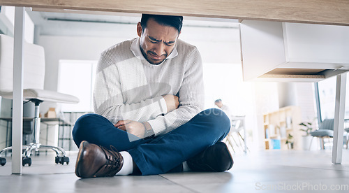 Image of Business stress, crying and burnout of a office employee suffering from mental health breakdown. Company business man with stomach pain and sad feeling under corporate desk with depression from work