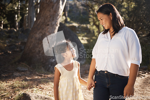 Image of Happy, child and mother walking in nature holding hands, bonding or talking as mother and daughter outdoors. Smile, happy family and young girl enjoys quality time with a lovely mama or mom in Peru