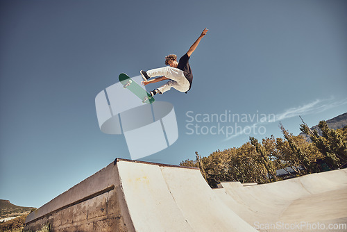 Image of Sports, skateboarding and skater in air at park doing tricks, skating and having fun in urban town. Fitness, freedom and man do action skills, jumping and cool movement for sport, hobby and exercise