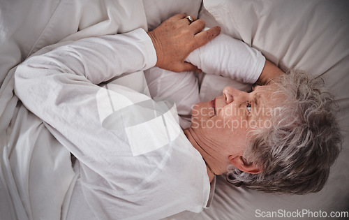 Image of Senior woman, bed and insomnia stress in house while tired, worry and anxiety in retirement. Elderly lady, home bedroom and mental health with headache, frustrated and fail to sleep in nursing home