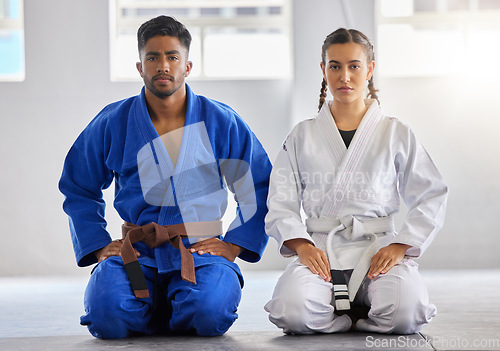 Image of Karate, man and woman in portrait together with focus determination for fitness, wellness or training. Couple, martial arts and sitting knees in gym, dojo or club for exercise, fight sport or workout