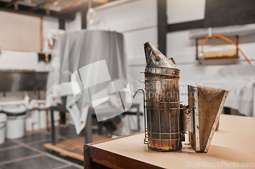 Image of Sustainability, beekeeping and copper smoker in warehouse or factory at bee farm. Farming, bees and growth in agriculture, eco friendly honey manufacturing industry and safety in honeycomb production